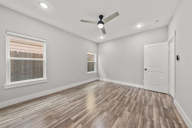 unfurnished room with a ceiling fan, recessed lighting, wood finished floors, and baseboards