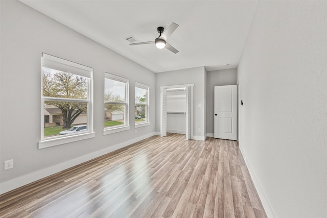 unfurnished bedroom with ceiling fan, a closet, visible vents, light wood finished floors, and baseboards