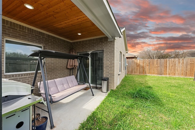 patio terrace at dusk with fence and a lawn