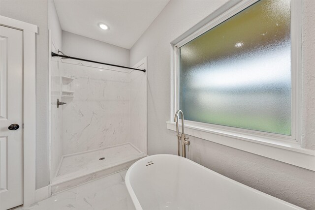 full bath with a shower stall, marble finish floor, and a freestanding tub