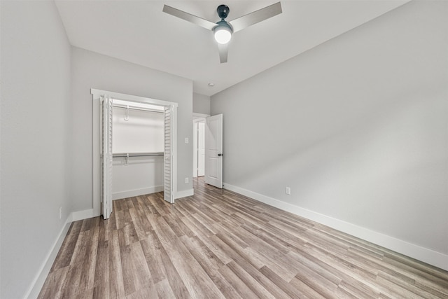 unfurnished bedroom with a closet, baseboards, light wood finished floors, and ceiling fan