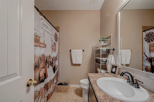 bathroom featuring visible vents, toilet, vanity, tile patterned floors, and a textured ceiling