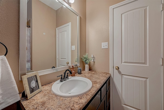 bathroom featuring vanity and a textured wall