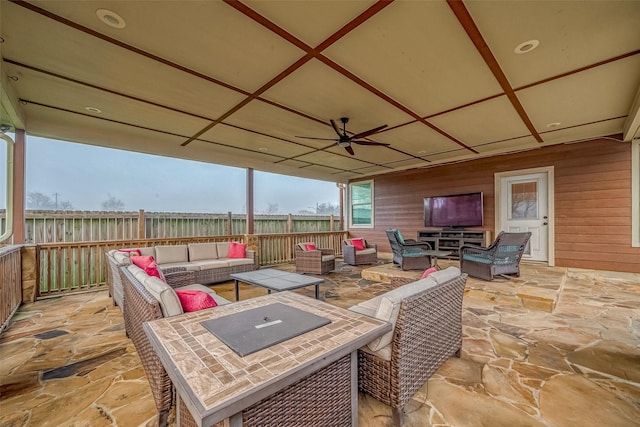 view of patio / terrace featuring a ceiling fan, an outdoor living space, and fence