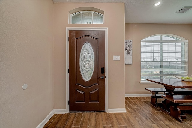 foyer entrance featuring visible vents, recessed lighting, baseboards, and wood finished floors