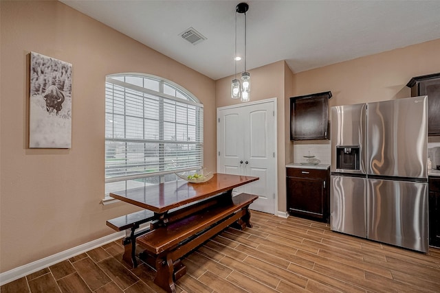 dining room with baseboards, visible vents, and wood tiled floor