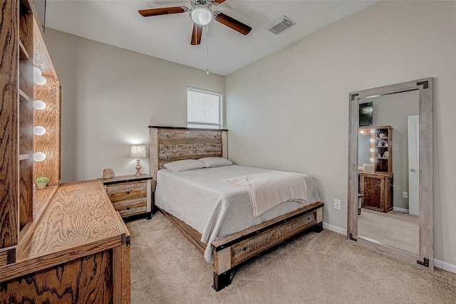 bedroom featuring visible vents, light colored carpet, a ceiling fan, and baseboards