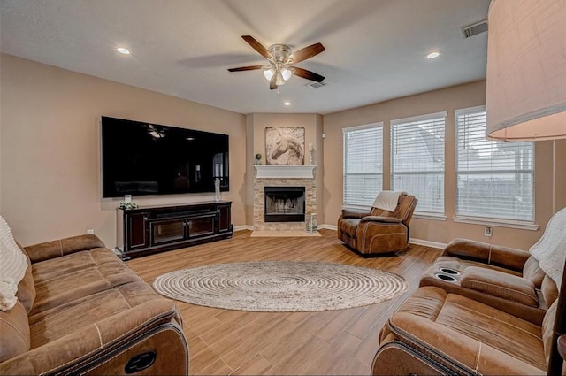 living room featuring visible vents, a fireplace, and light wood-type flooring