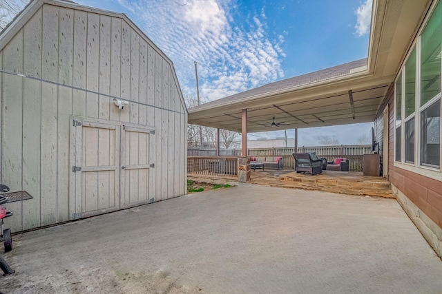 exterior space featuring a shed, driveway, an outdoor structure, and fence