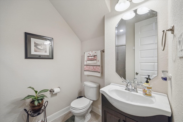 bathroom with baseboards, lofted ceiling, toilet, and vanity