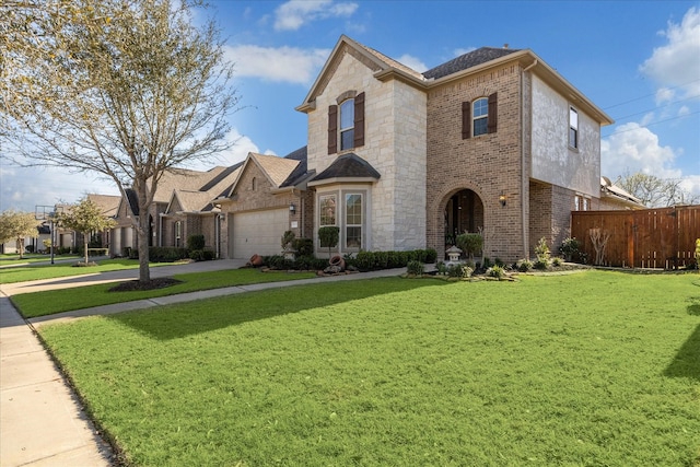 view of front facade featuring a garage, brick siding, a front yard, and fence