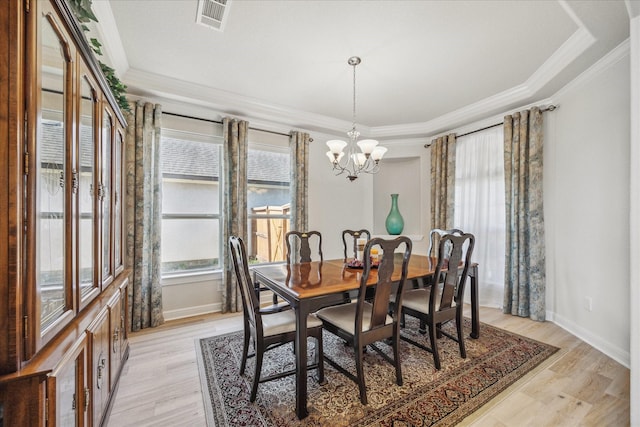 dining space with light wood finished floors, visible vents, crown molding, baseboards, and an inviting chandelier