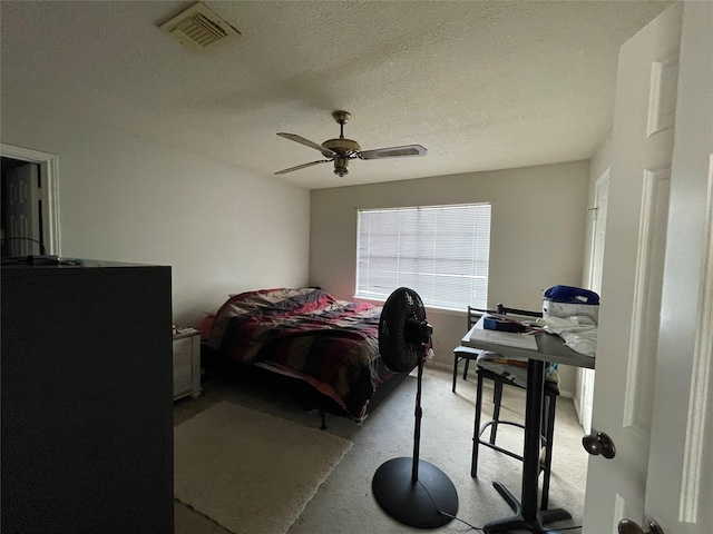 bedroom featuring visible vents, a textured ceiling, and ceiling fan