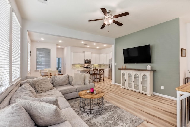 living area with visible vents, recessed lighting, light wood finished floors, baseboards, and ceiling fan