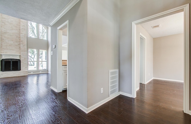 hallway with visible vents, baseboards, and dark wood-style flooring