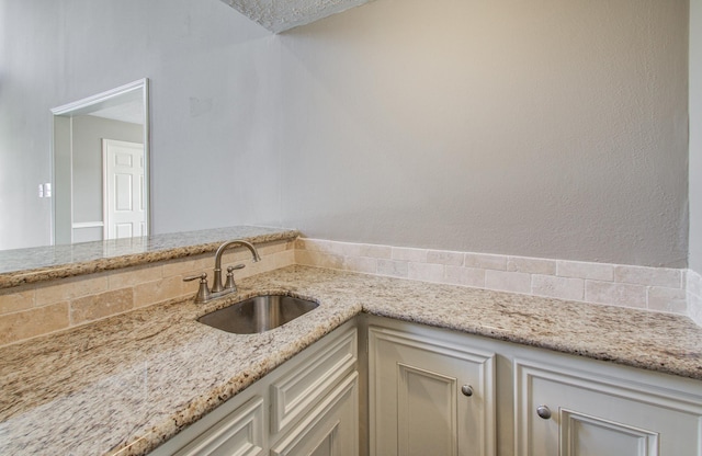 kitchen featuring light stone countertops and a sink