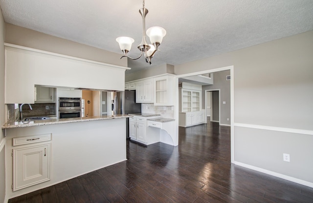 kitchen featuring a sink, decorative backsplash, light stone countertops, and dark wood-style flooring