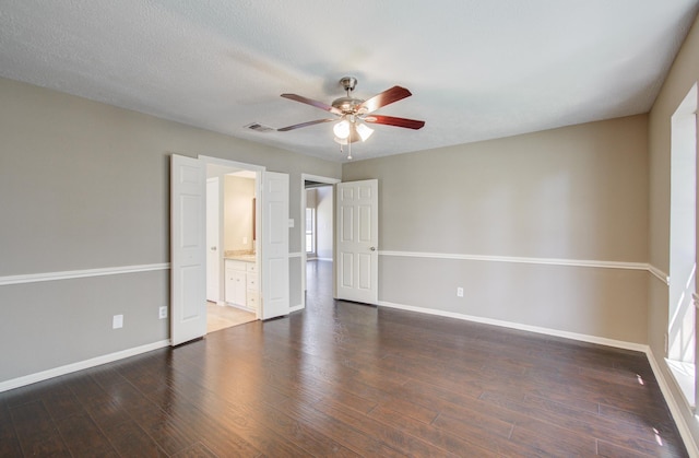 unfurnished room with ceiling fan, wood finished floors, visible vents, and baseboards