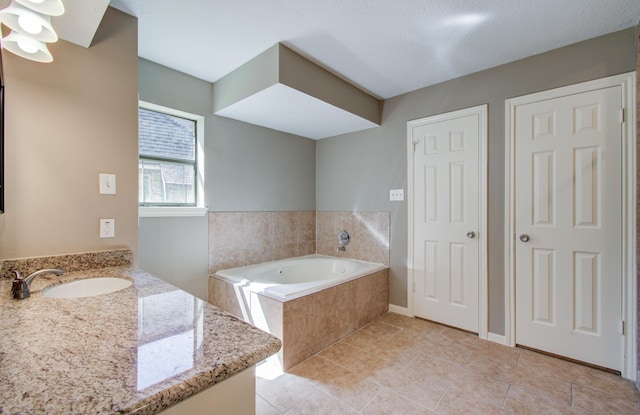 bathroom featuring a bath, tile patterned floors, vanity, and baseboards