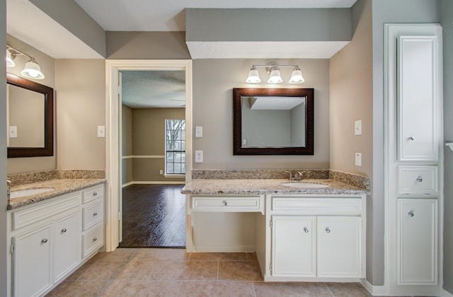 full bathroom with a sink, two vanities, and tile patterned floors