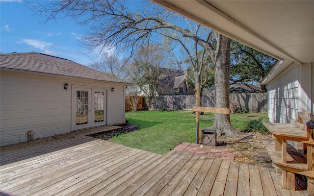 wooden deck with a fenced backyard, french doors, and a yard