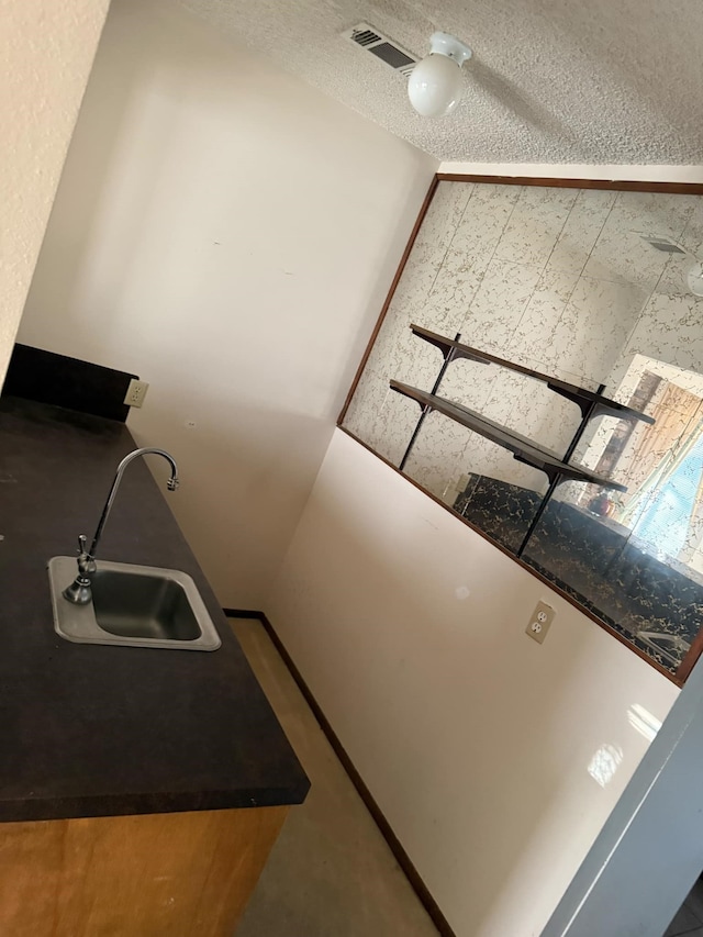 kitchen with a sink, visible vents, and a textured ceiling