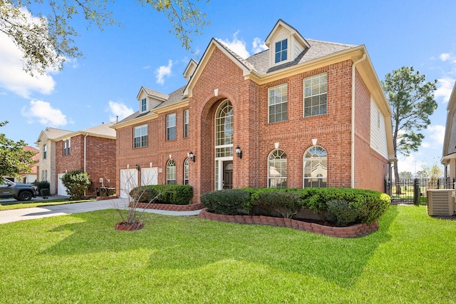 colonial-style house with central air condition unit, brick siding, and driveway