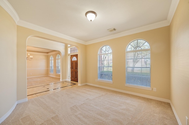 carpeted entryway with arched walkways, visible vents, a chandelier, and baseboards