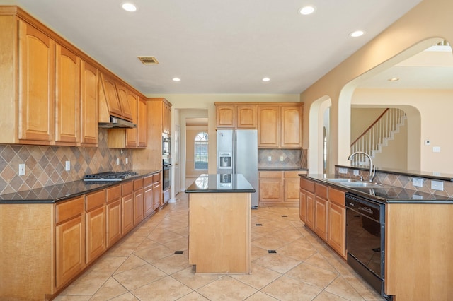 kitchen with black appliances, dark countertops, visible vents, and a kitchen island