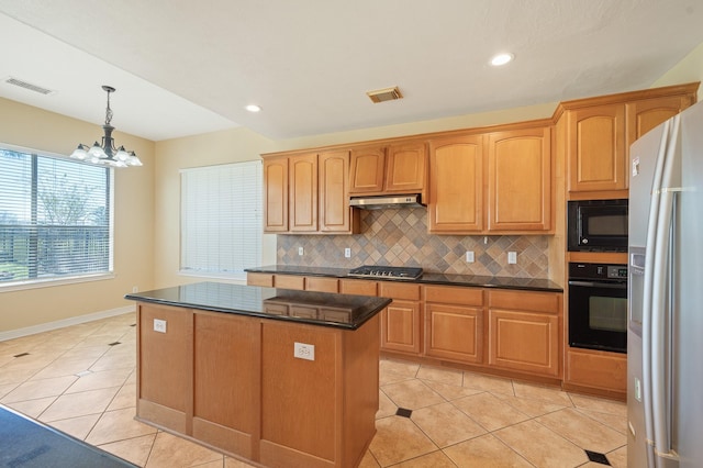 kitchen featuring visible vents, a kitchen island, black appliances, under cabinet range hood, and backsplash