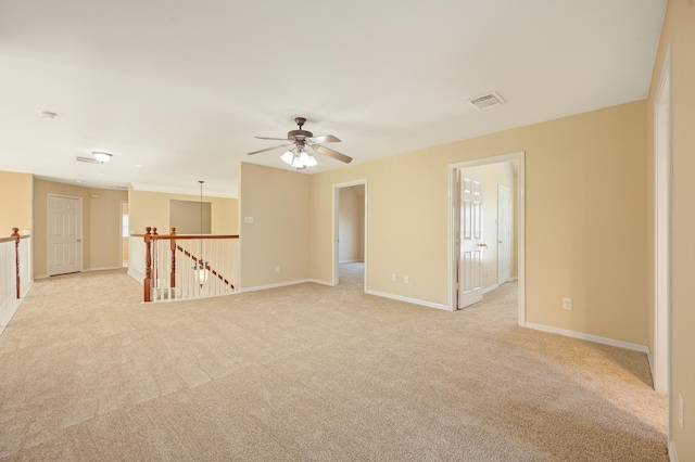 empty room with light carpet, visible vents, and baseboards