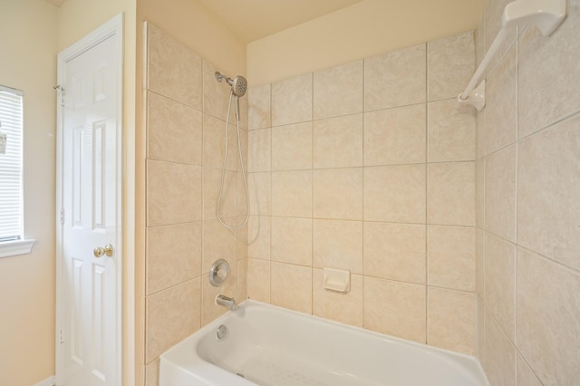 bathroom featuring a wealth of natural light and washtub / shower combination