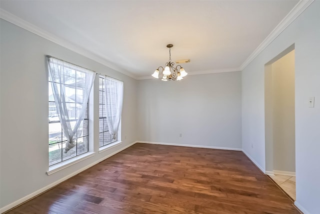 empty room featuring baseboards, a notable chandelier, wood finished floors, and ornamental molding