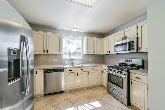 kitchen with a sink, light countertops, cream cabinetry, and stainless steel appliances