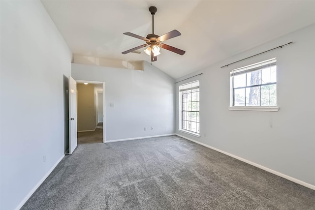 carpeted spare room featuring baseboards, ceiling fan, and vaulted ceiling