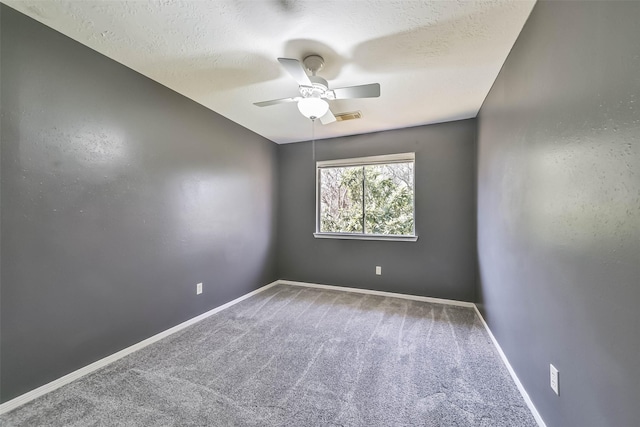 carpeted empty room featuring visible vents, ceiling fan, a textured ceiling, and baseboards