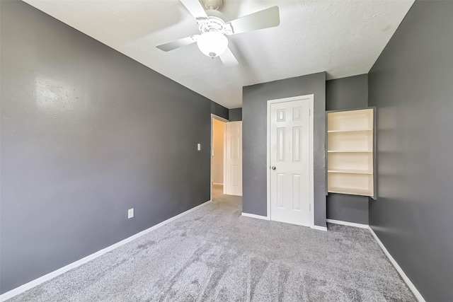 unfurnished bedroom featuring a closet, baseboards, carpet, and a ceiling fan