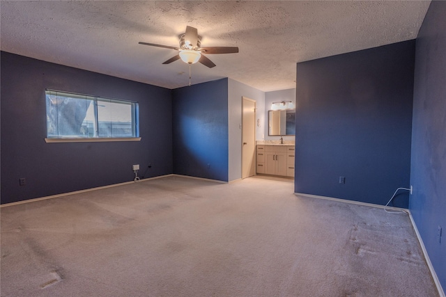 unfurnished room featuring a ceiling fan, light colored carpet, baseboards, and a textured ceiling