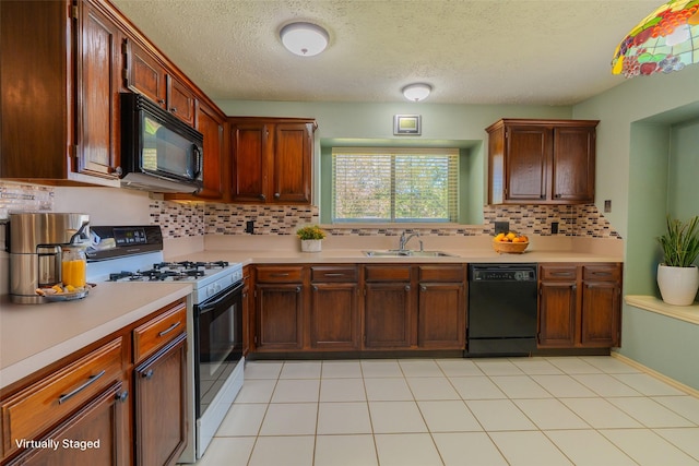 kitchen featuring black appliances, a sink, backsplash, light tile patterned flooring, and light countertops