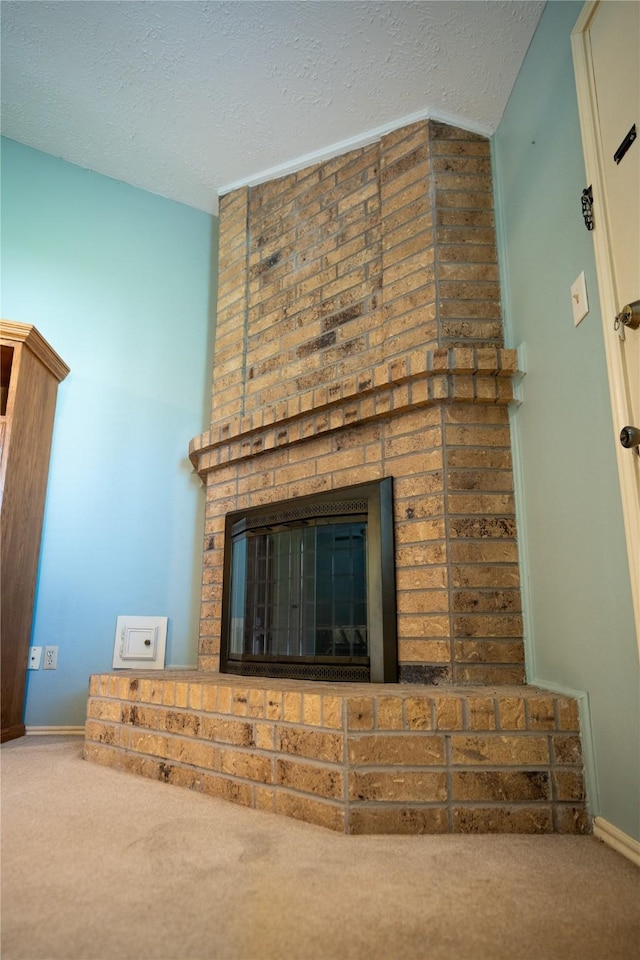 room details with carpet flooring, a fireplace, a textured ceiling, and baseboards