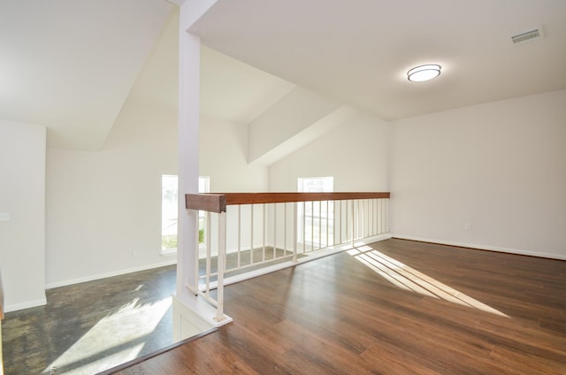 additional living space with visible vents, baseboards, high vaulted ceiling, and wood finished floors