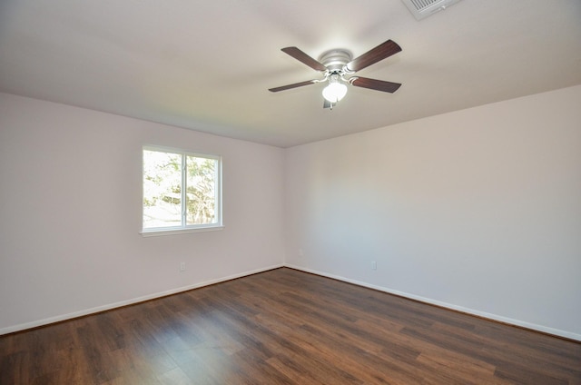 empty room featuring visible vents, baseboards, dark wood-style flooring, and ceiling fan