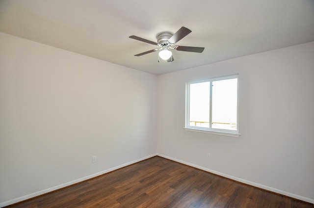 spare room with ceiling fan, baseboards, and dark wood finished floors