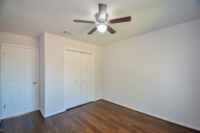 unfurnished bedroom featuring a ceiling fan, dark wood-style floors, visible vents, baseboards, and a closet