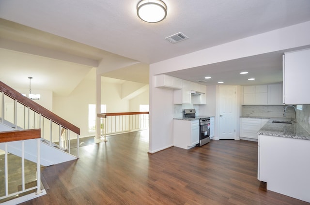 kitchen featuring tasteful backsplash, light stone countertops, dark wood finished floors, stainless steel range with electric stovetop, and a sink