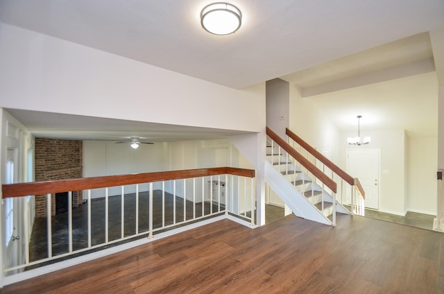 interior space featuring stairs, ceiling fan with notable chandelier, and wood finished floors