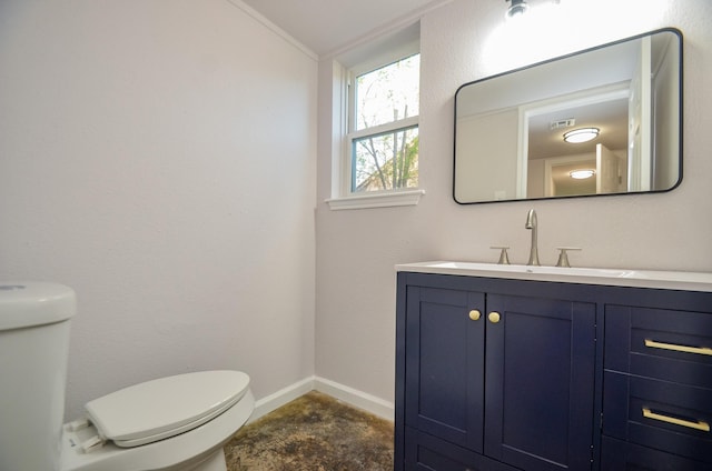 bathroom with vanity, toilet, and baseboards