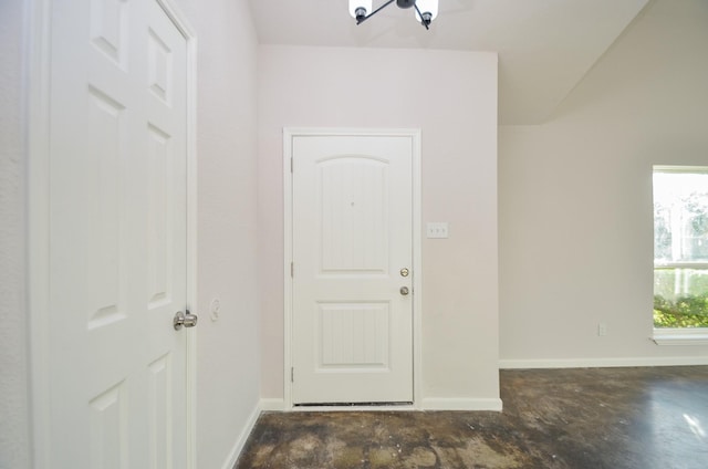 foyer entrance with baseboards and concrete floors