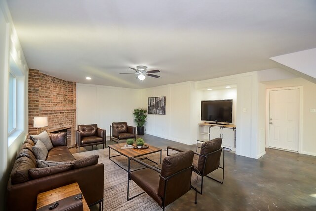 living room with baseboards, finished concrete floors, recessed lighting, a fireplace, and a ceiling fan