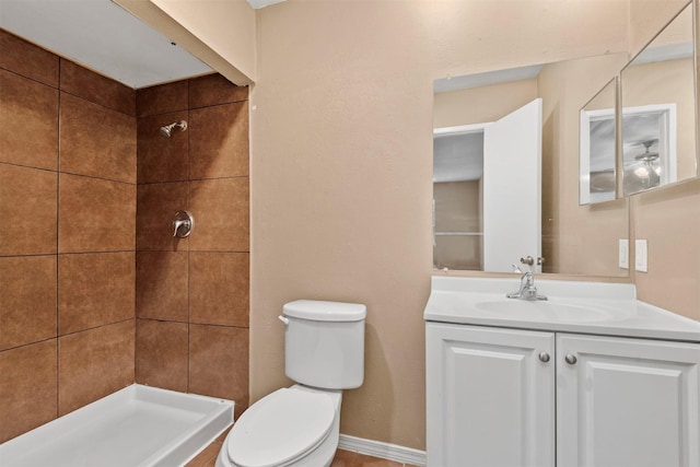 bathroom featuring a shower stall, toilet, vanity, and baseboards